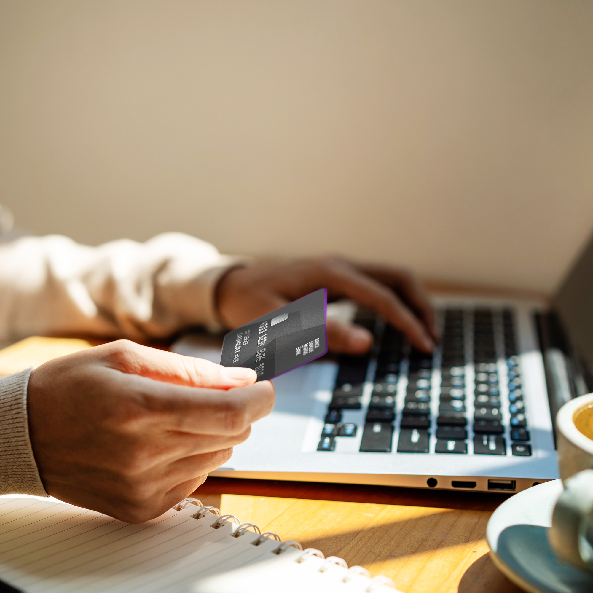 Nahaufnahme Person hält Bankkarte am Laptop sitzend