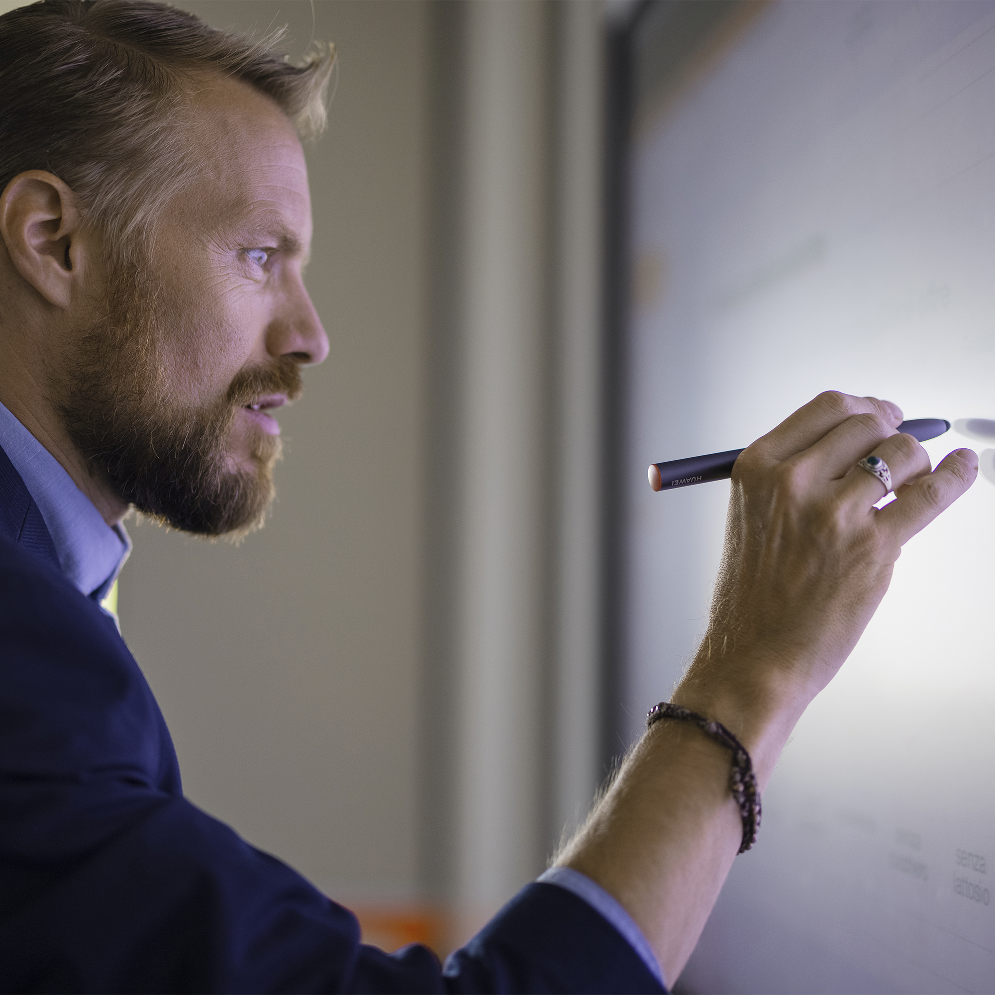 Mann in Anzug schreibt mit einem Stift auf digitalen Screen