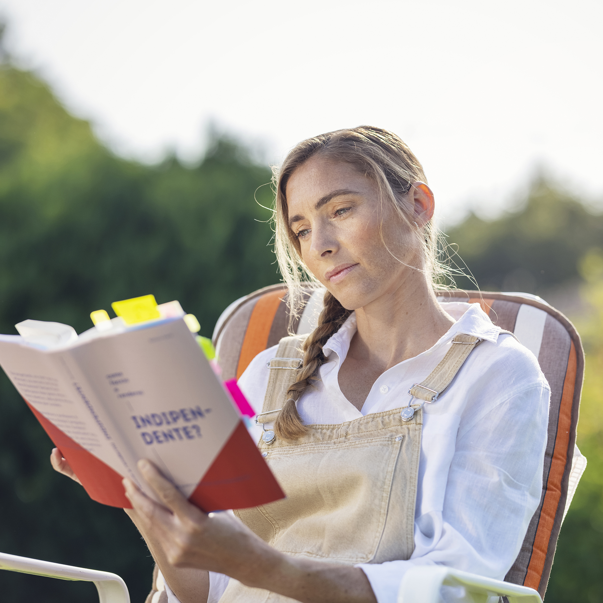 Frau draussen mit Buch in der Hand