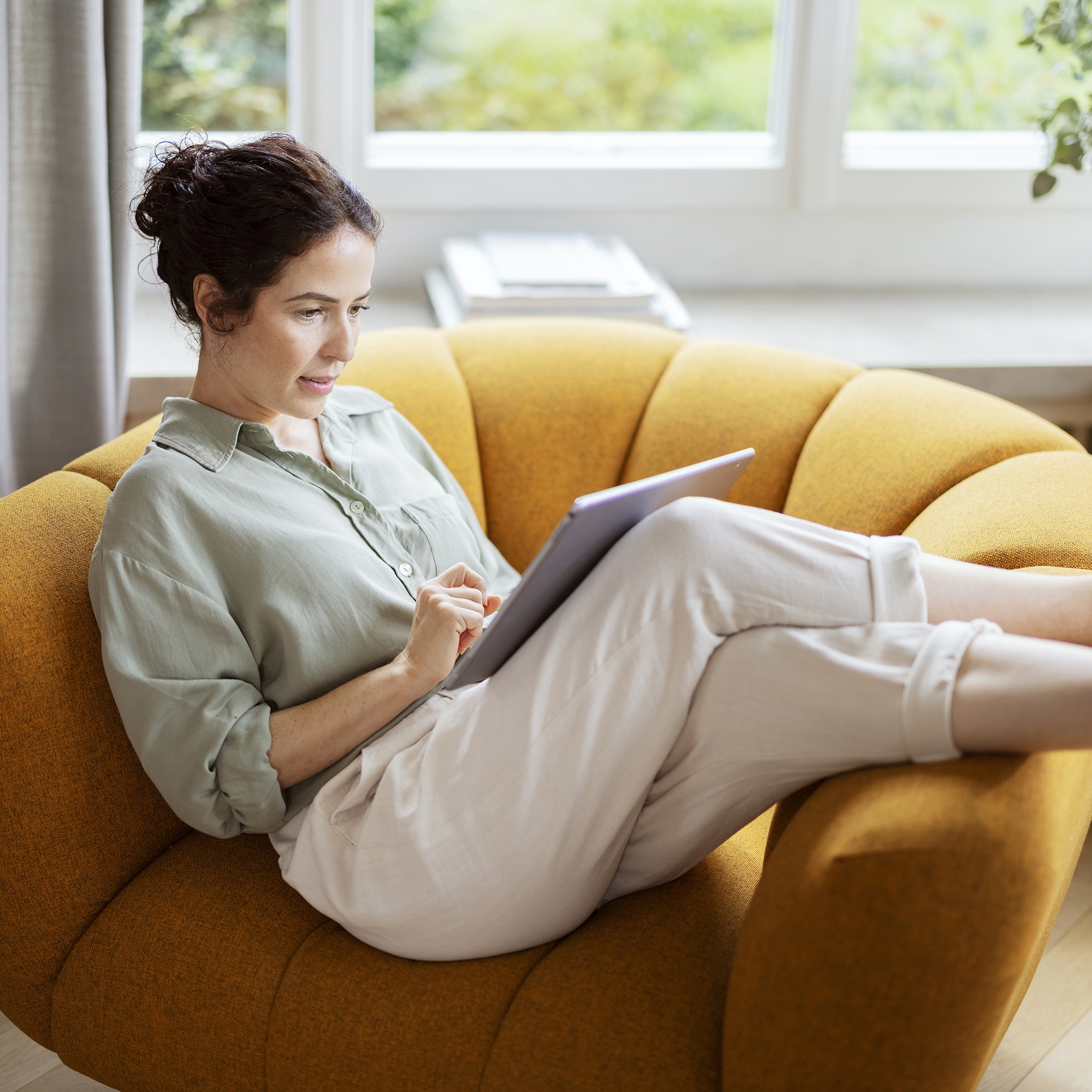 Frau sitzt zuhause auf dem Sofa